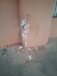 broken stucco and wall outside commercial store front